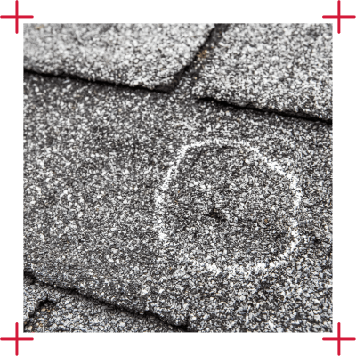 roof inspection with marked hail damage on asphalt shingles